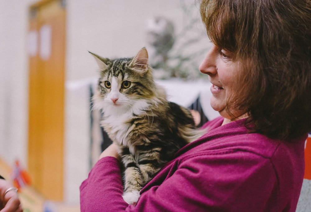 woman holding brown and white cat