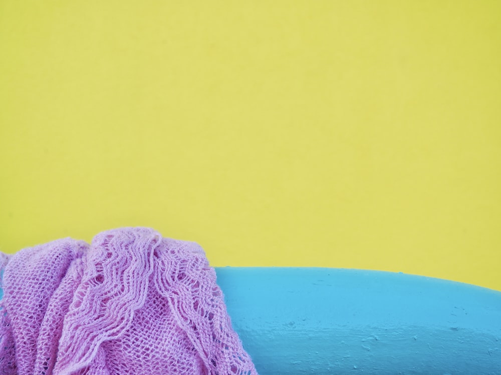 a blue and purple object on a yellow and blue background