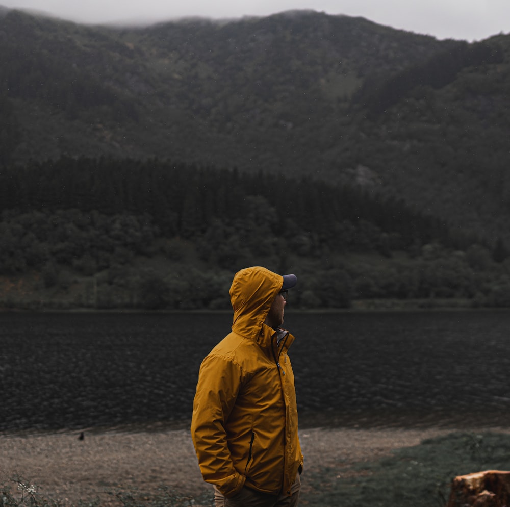 man in yellow jacket on lake