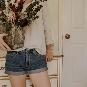 A delivery person handing a beautiful floral arrangement at a cozy home entrance.