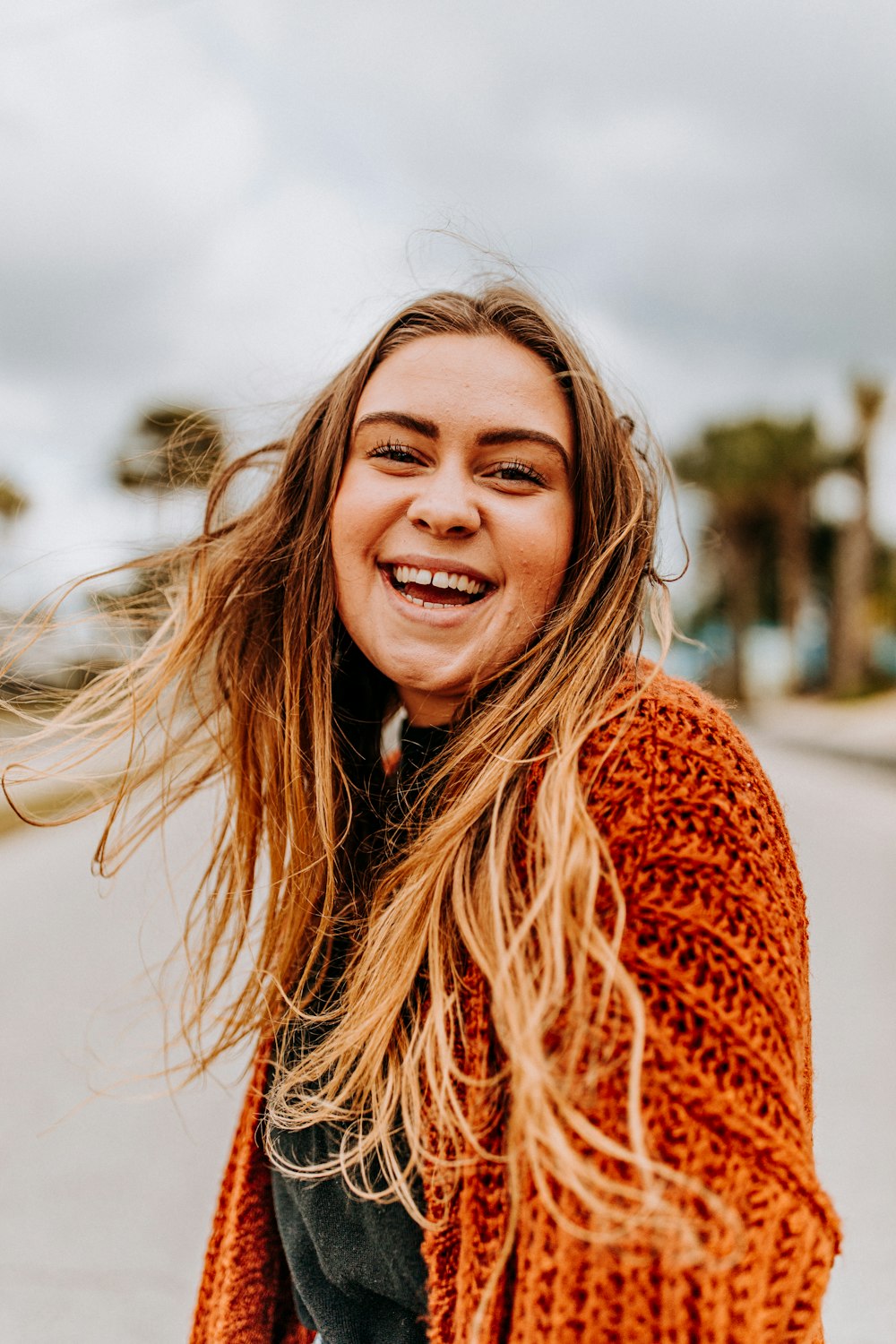 selective focus photography of smiling woman wearing brown cardigan
