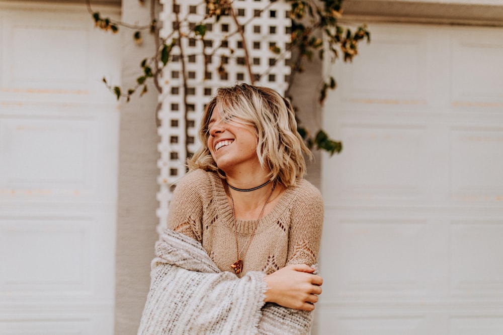 woman smiling in front of plant