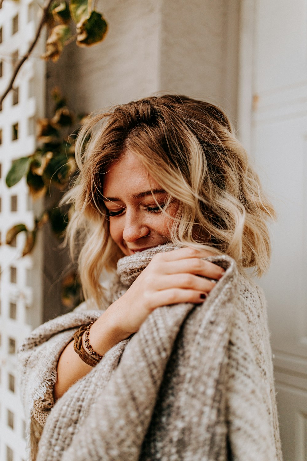 selective focus photography of standing woman holding gray blanket