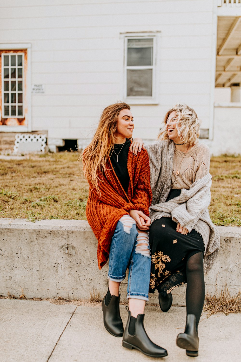 two woman sitting near the white house