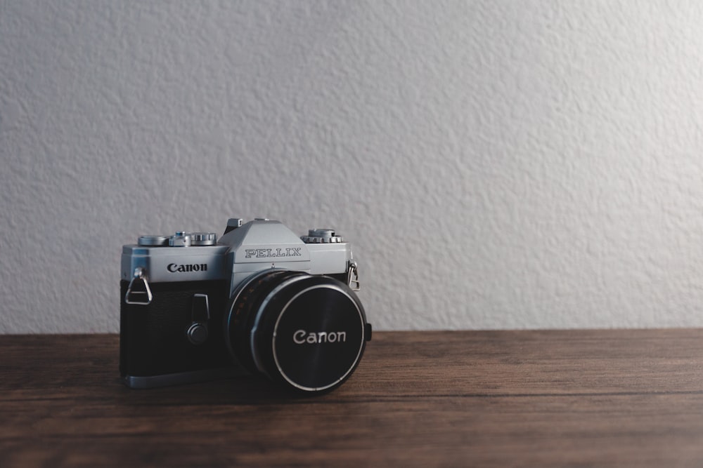 silver and black Canon Pellix SLR camera on brown surface