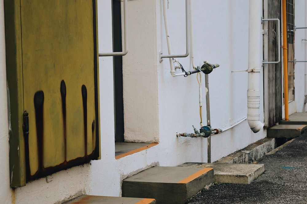 a white building with a yellow door and some steps