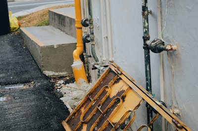An outdoor scene showing a technician inspecting pipes in a garden area.