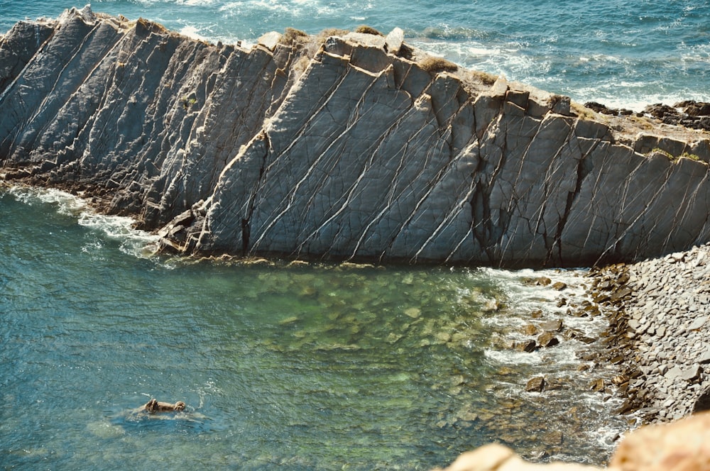 aerial photography of cliff viewing body of water during daytime