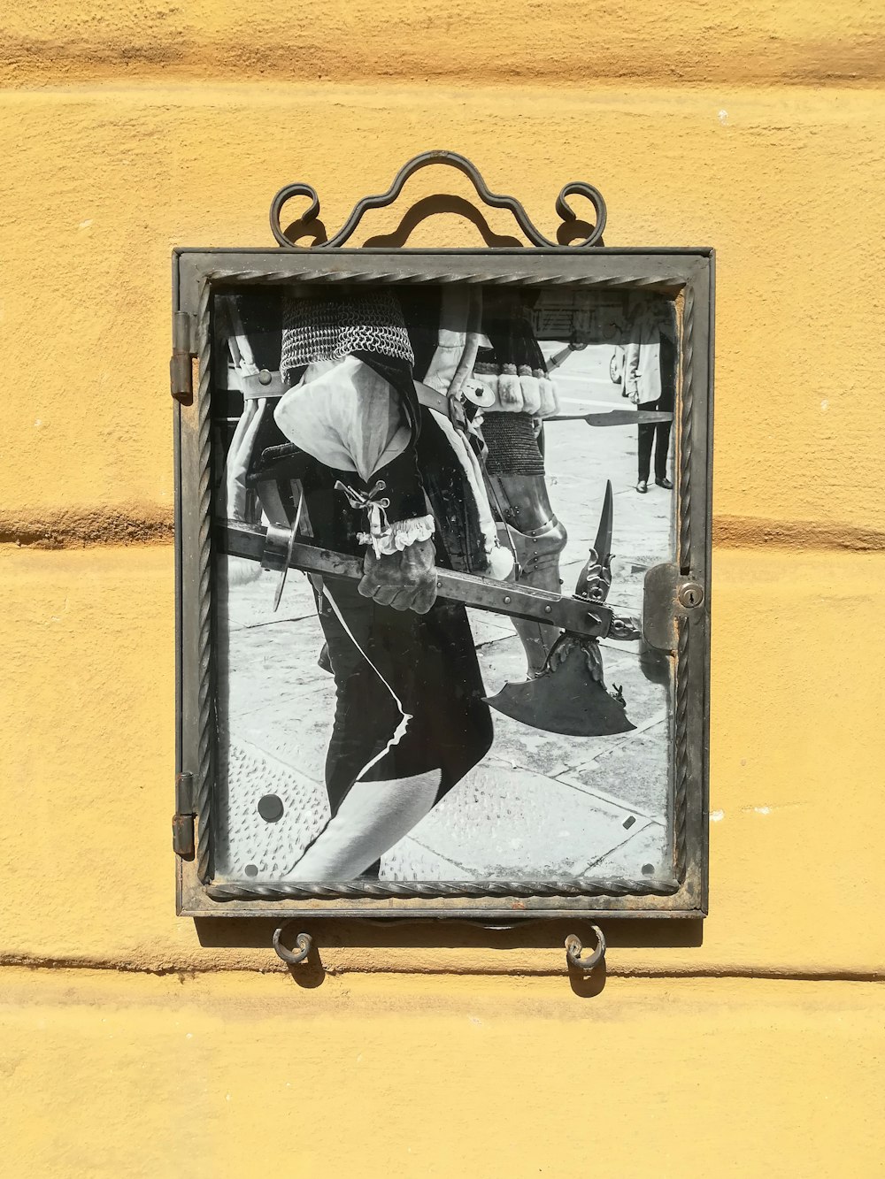 person holding weapon grayscale photo mounted on wall