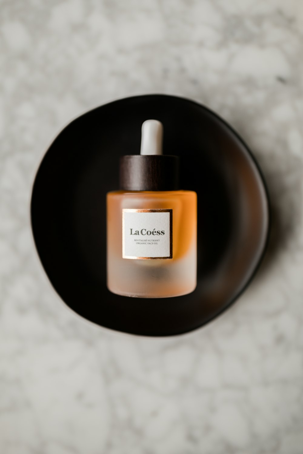 a bottle of perfume sitting on top of a black plate