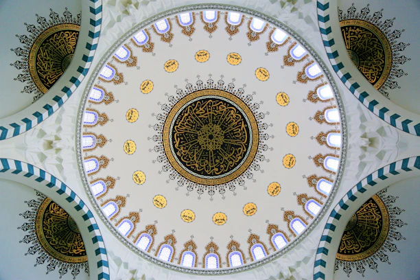 A serene mosque dome silhouette with intricate gold arabesque patterns glowing softly against a deep emerald background.