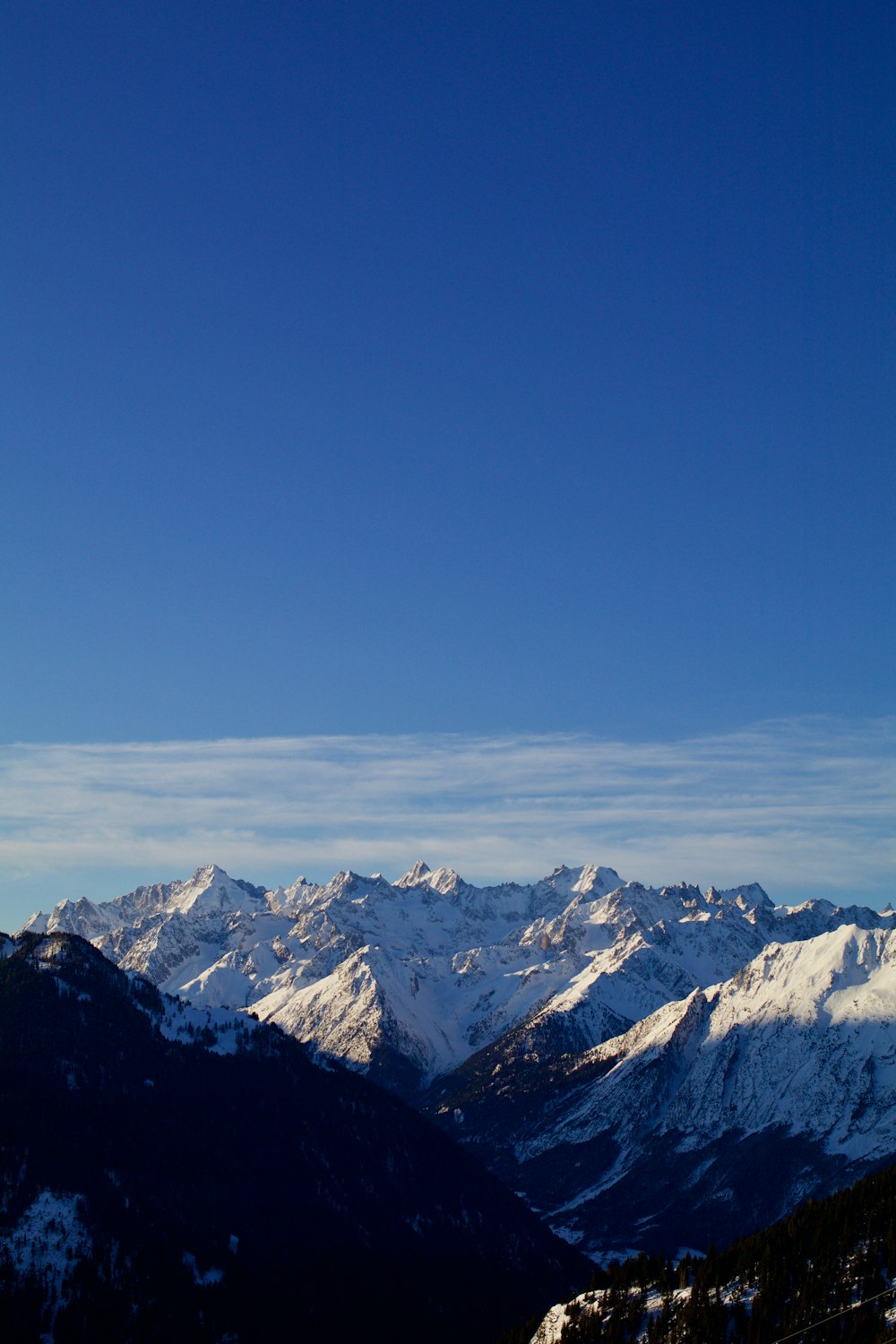 青と白の空の下で雪に覆われた山の航空写真