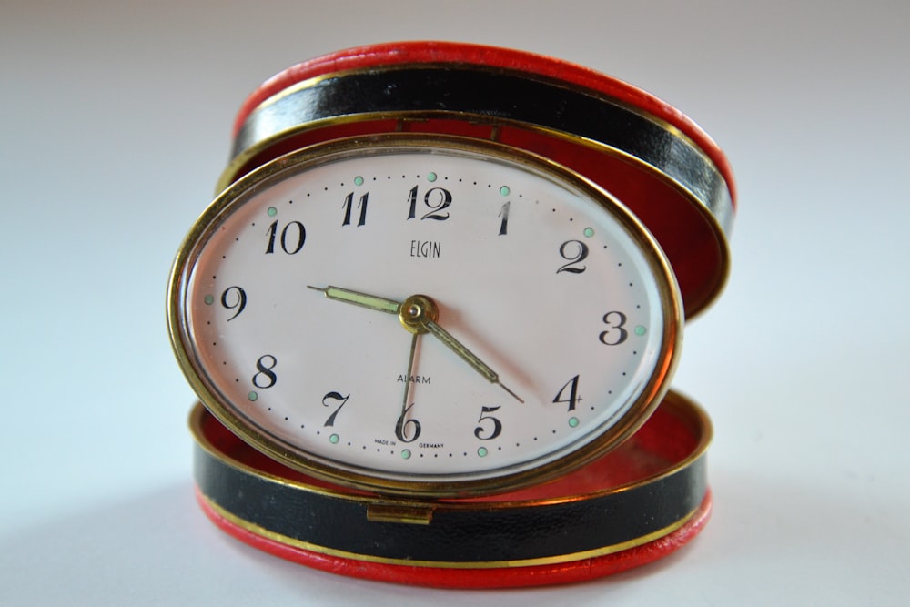 oval white and orange analog clock