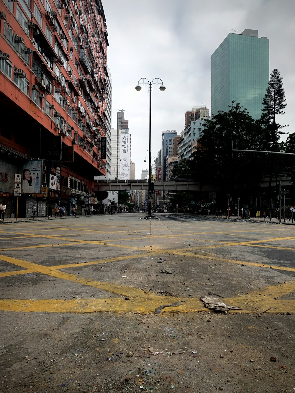 gray concrete road in between high rise buildings during daytime
