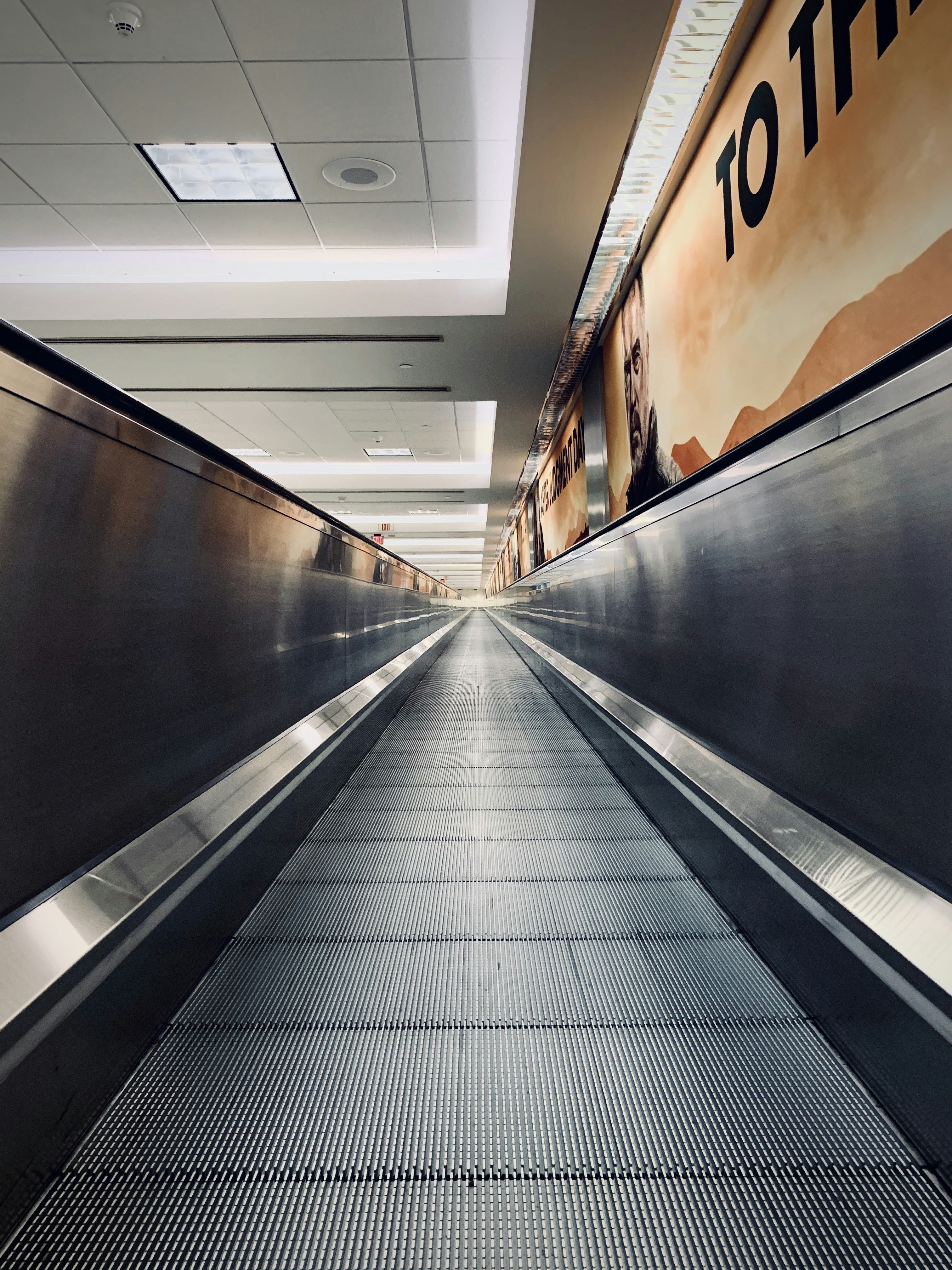 an empty escalator in a building with a sign on the wall
