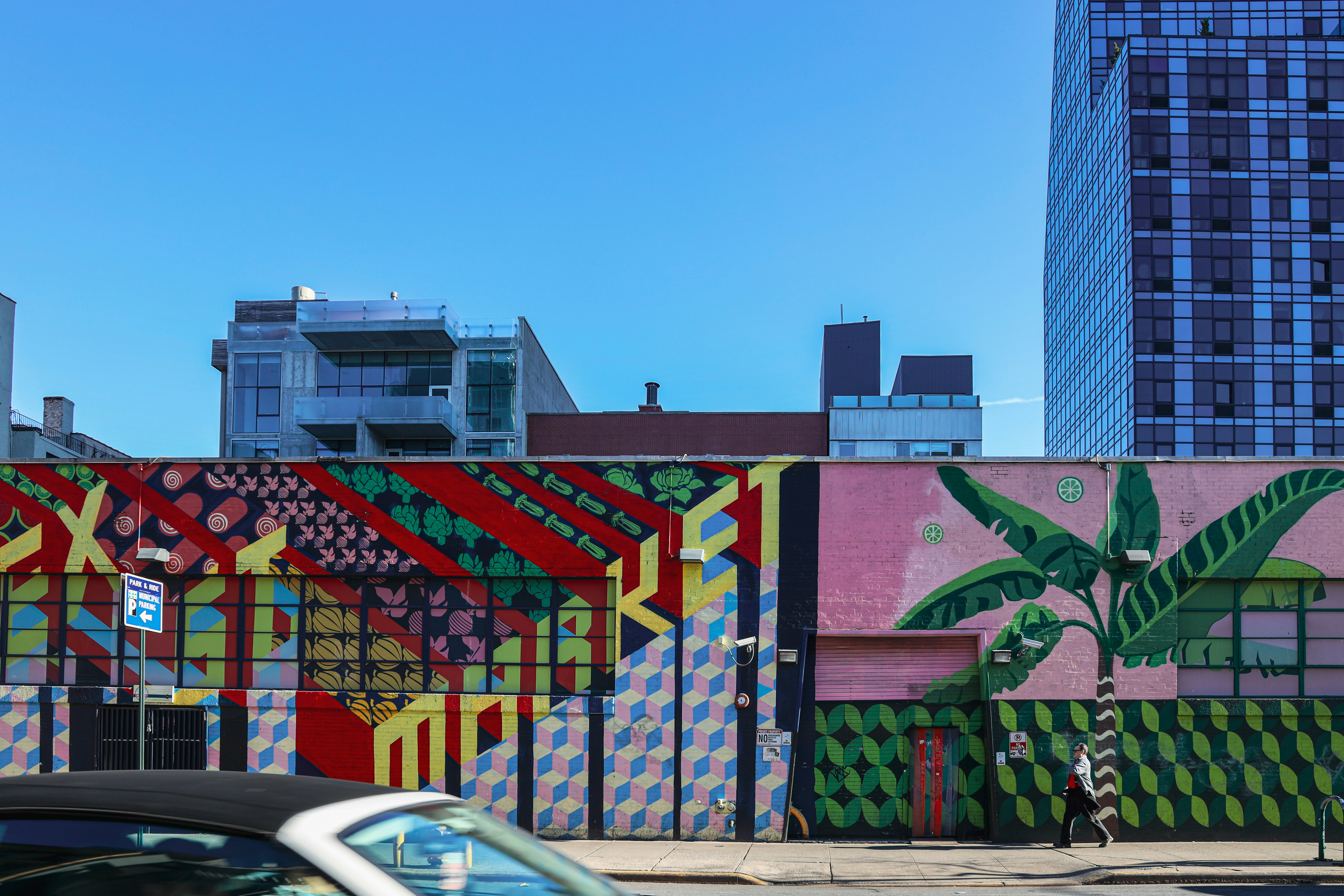 person walking beside building with murals during day, Palming Skies</p><p>@ Lower Manhattan, Manhattan