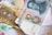 A close-up view of various Chinese currency notes placed on top of a document. Prominent features include traditional Chinese characters, intricate patterns, and a portrait of a notable individual on one of the notes. The document underneath has clearly visible English text and numerical values.