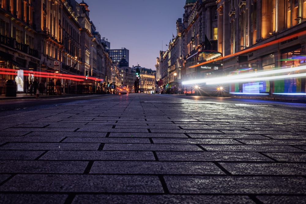 gray brick road between buildings during night time