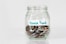 coins in clear glass jar with house fund sign