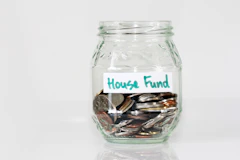 Coins in a glass jar labeled house fund