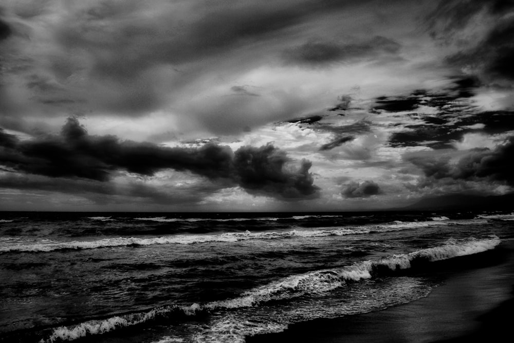 grayscale photo of ocean under cloudy sky