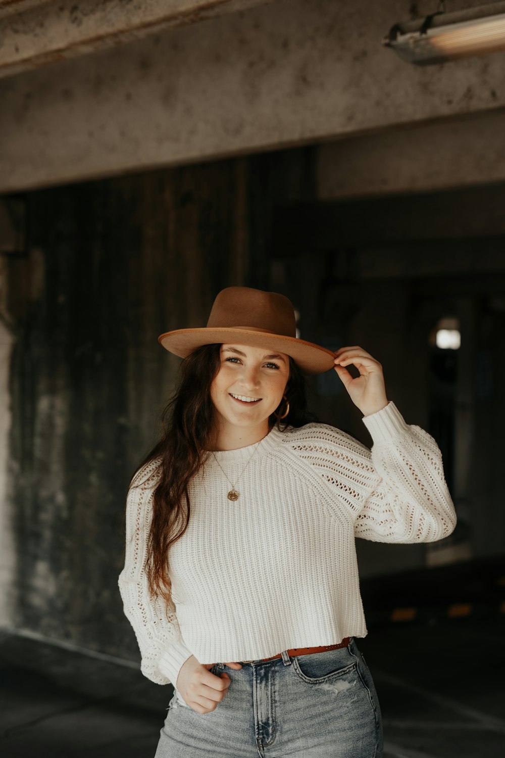 smiling woman holding her hat