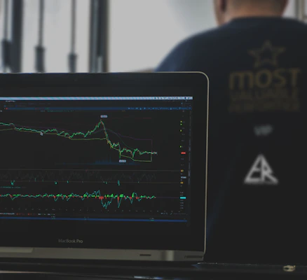 A focused entrepreneur reviewing financial charts with a laptop and notes in a cozy office space.