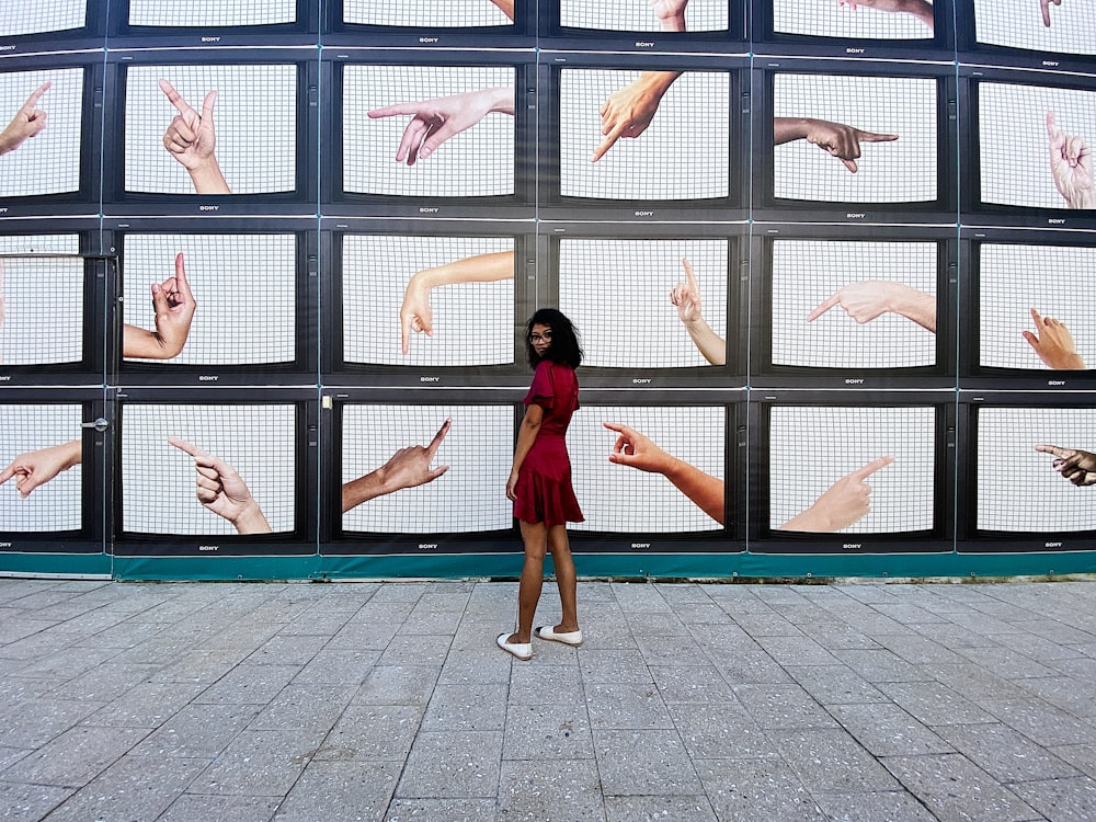 woman in red dress near monitors