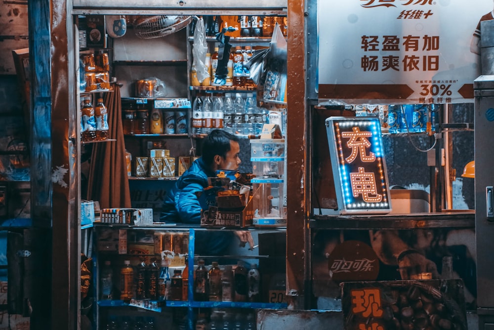 a man standing in front of a store filled with items