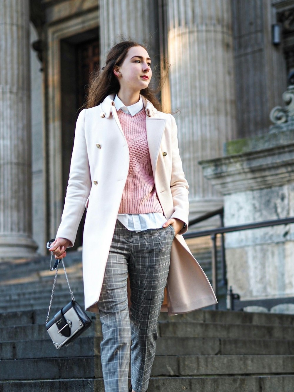 woman wearing white coat carrying crossbody bag