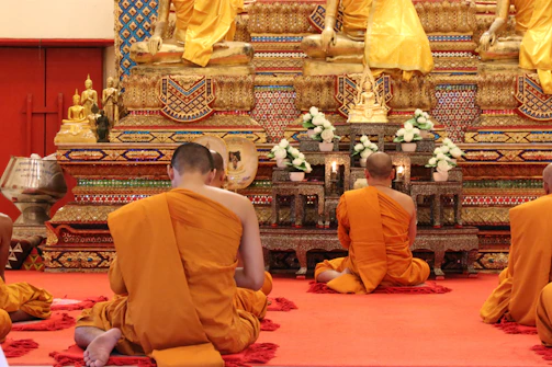 person in orange top sitting in front of statue