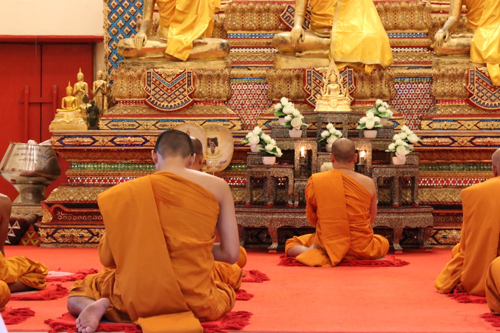 person in orange top sitting in front of statue