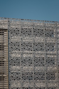 Close-up of intricately designed perforated panels installed on a modern building facade