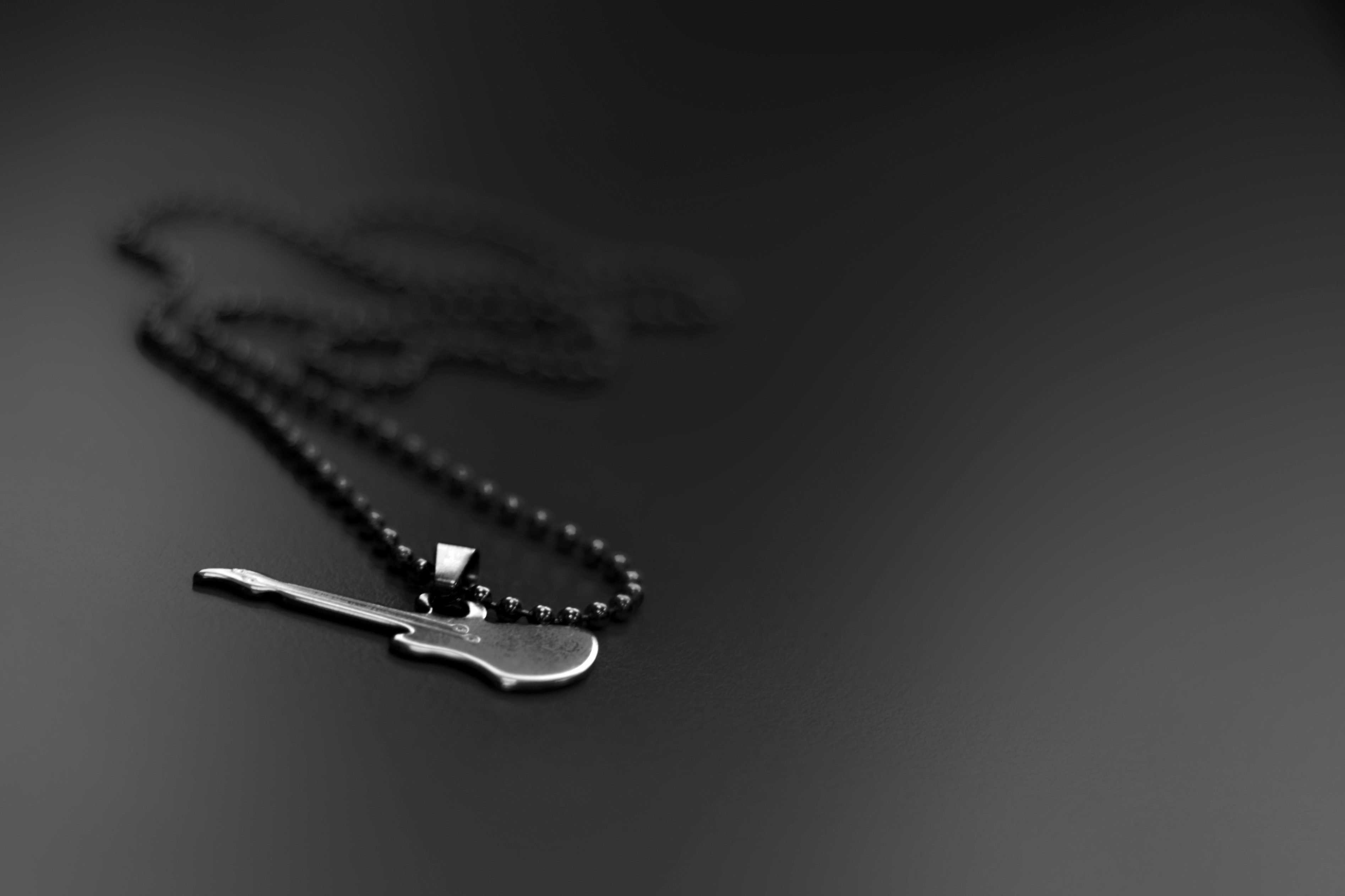 guitar pendant beaded necklace on black surface