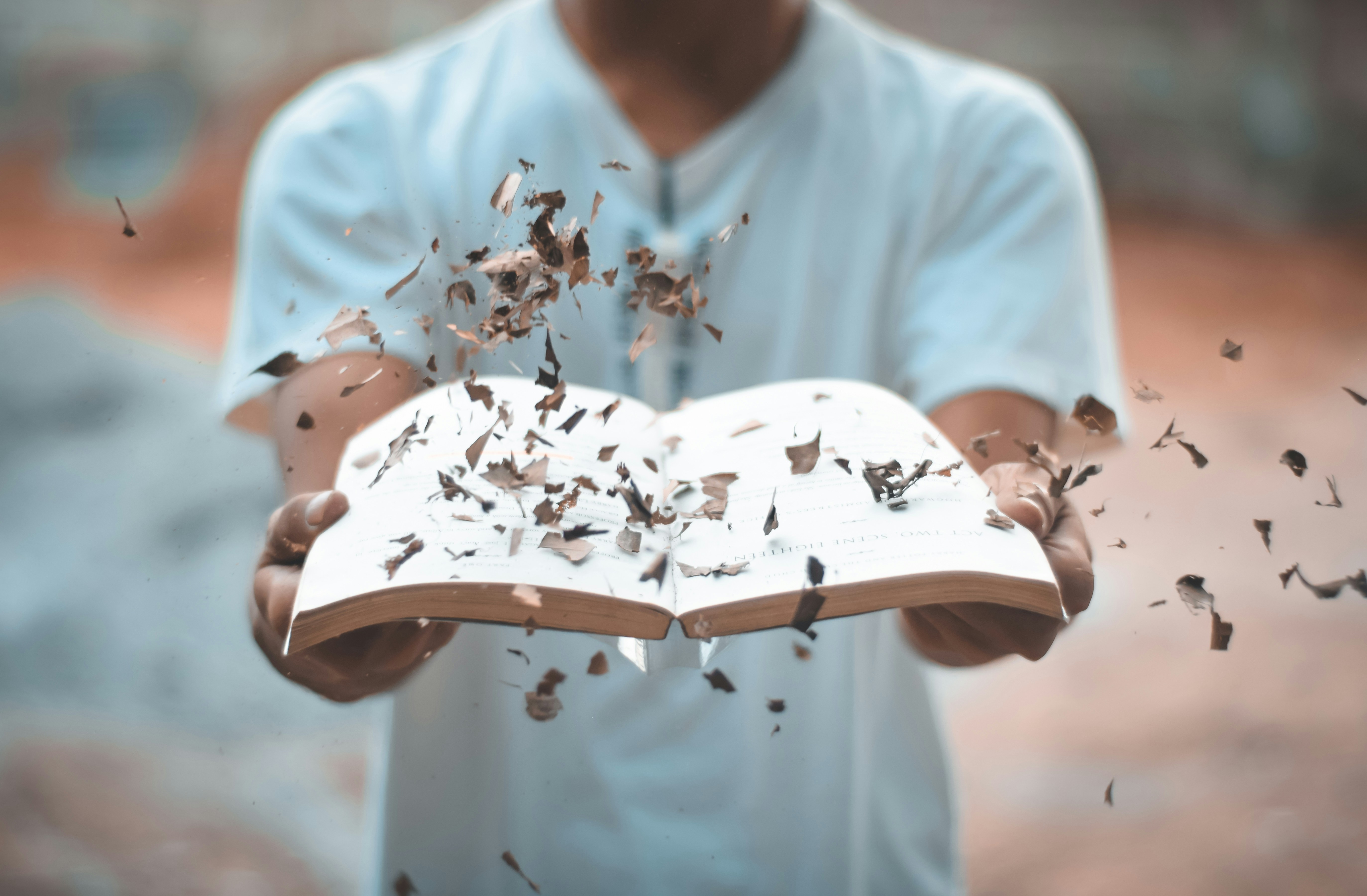 man opening book with leaves