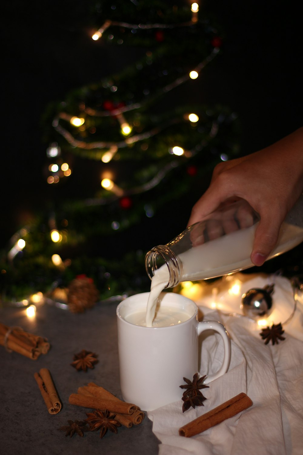 person pouring white liquid in mug