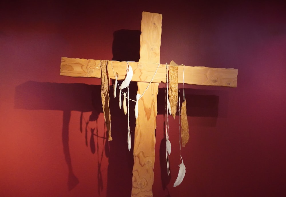 beige wooden cross beside wall