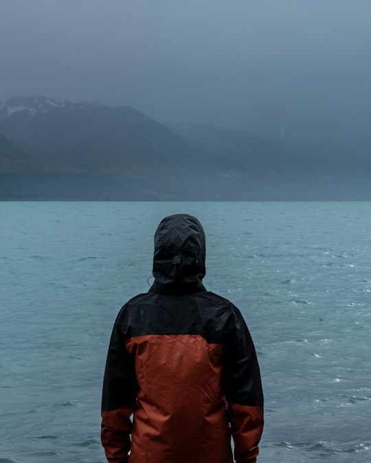 person standing near water in Tekapo New Zealand