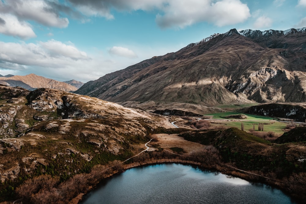 brown mountains and body of water during day