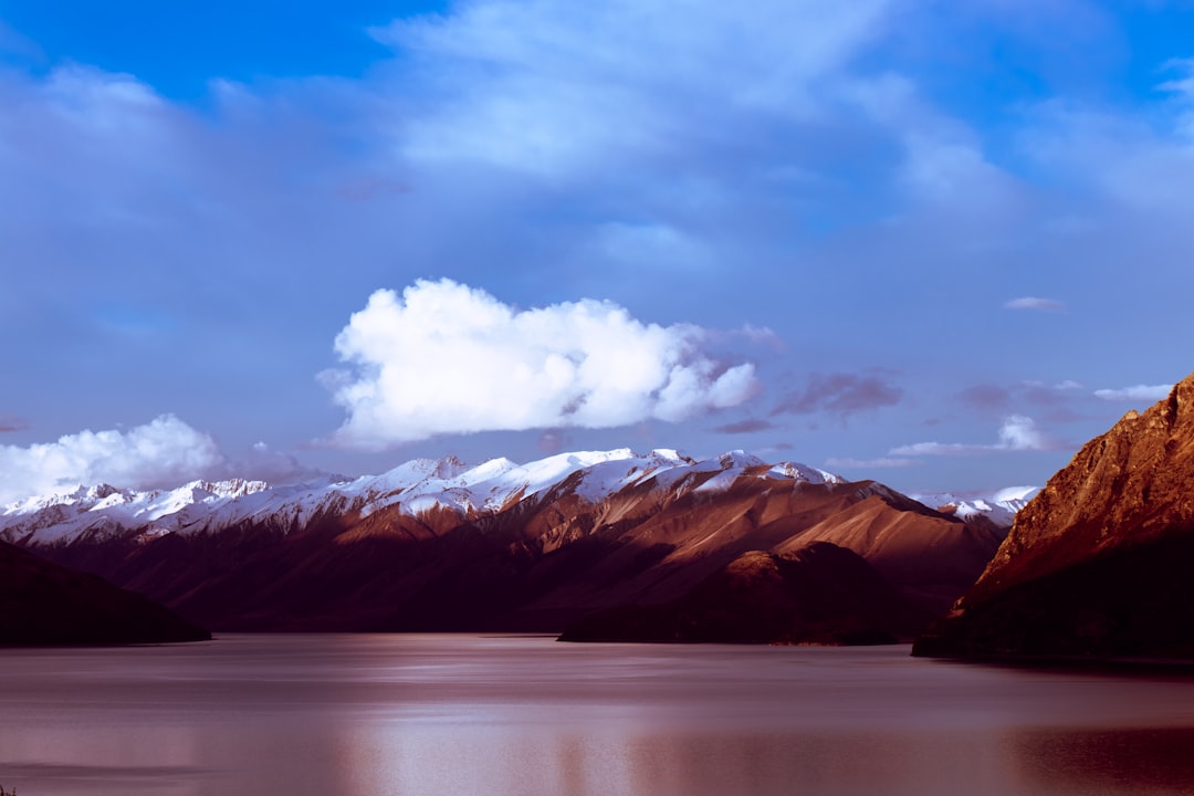 summit view of mountain covered with snow under white and blue sky