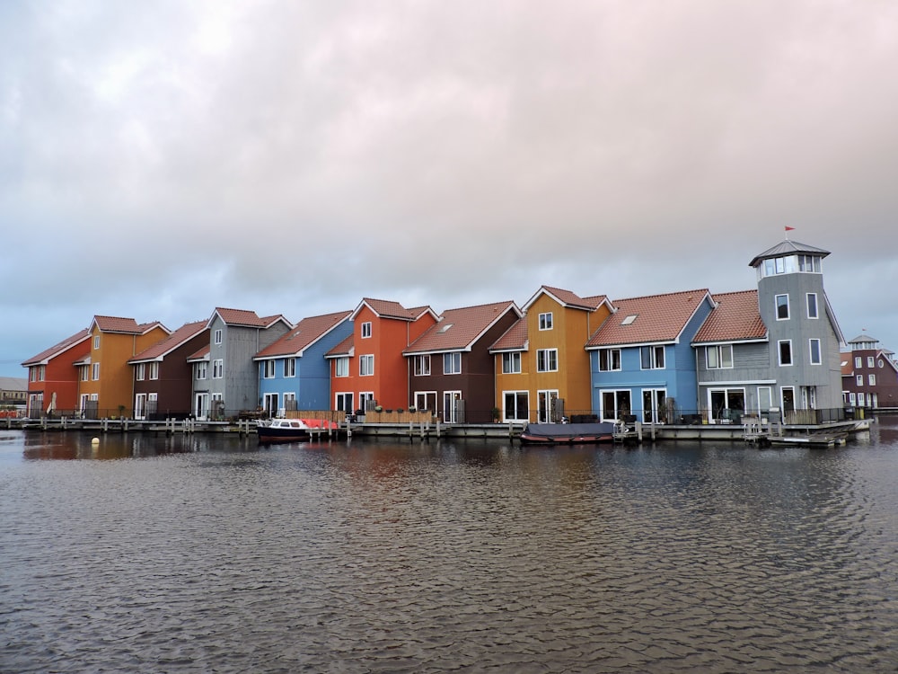 multicolored houses and buildings near body of water under white sky