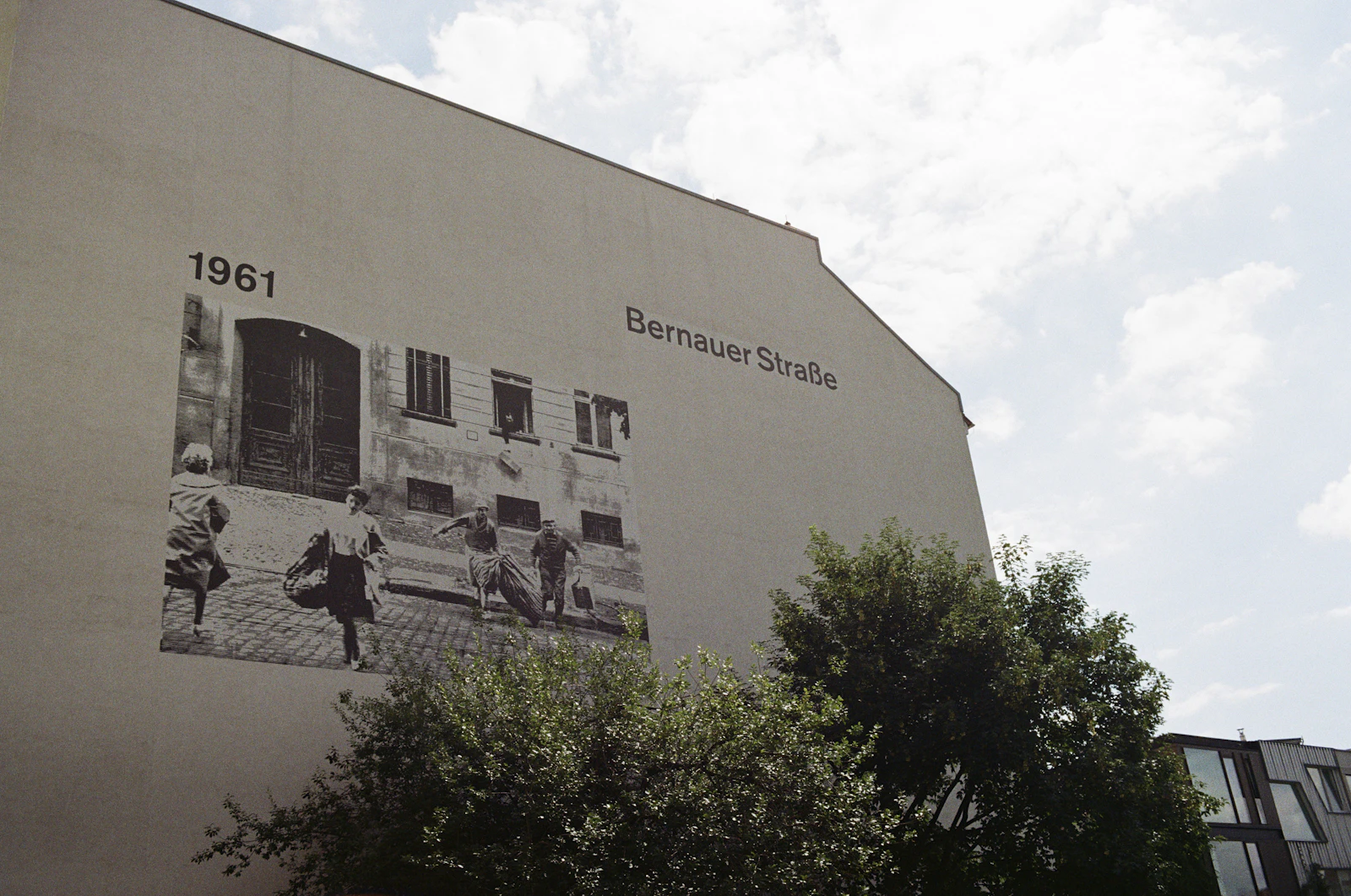 Travel photograph: A 1961 photograph and the words Bernauer Strasse cover a building beside the Berlin Wall Memorial.