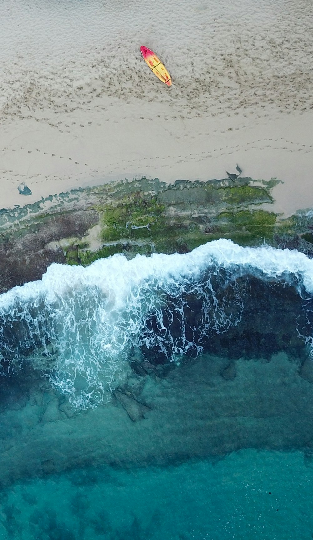 aerial photography of yellow and red kayak near body of water during daytime