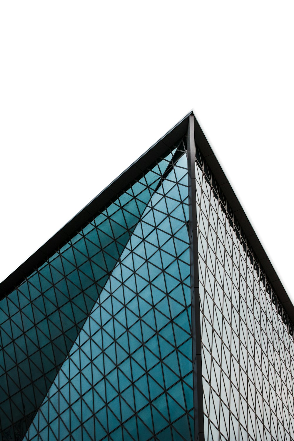 Photographie en contre-plongée d’un immeuble de grande hauteur aux murs de verre gris