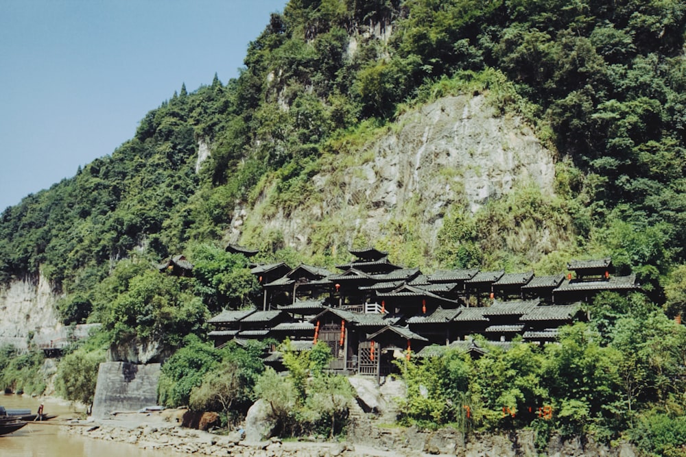 black wooden house under mountain with trees