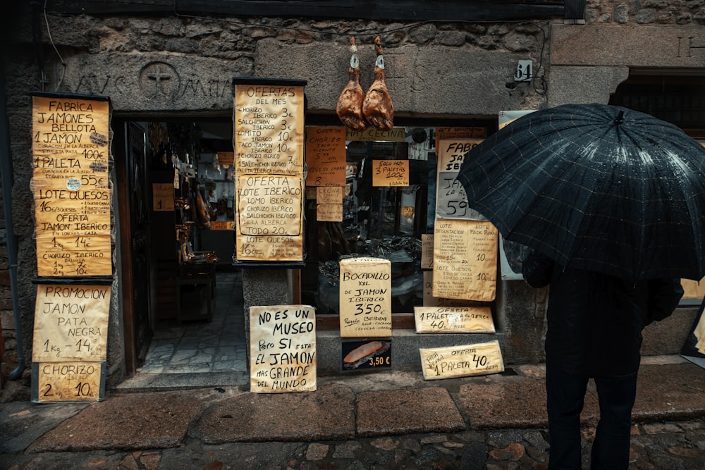 standing man holding black umbrella