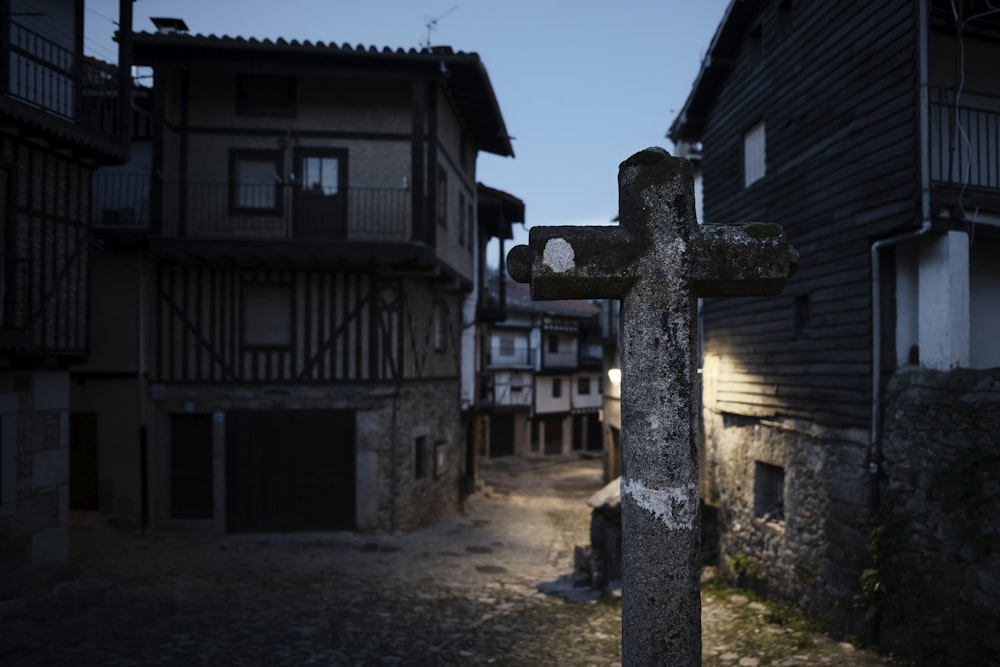 une croix sur le bord d’une route à côté d’un bâtiment