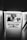 A narrow passageway leads to a small booth with a person inside wearing a hat, looking at some papers. On the booth window, there is a large sign that reads 'WANTED FULL / PART TIME DAY/NIGHT CONTROLLER' and a smaller 'WARNING' sign.