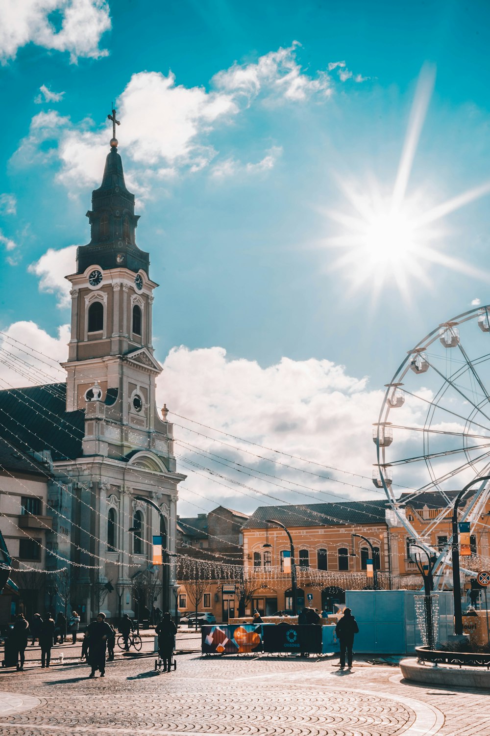 Ferris wheel beside gray concrete church during daytime