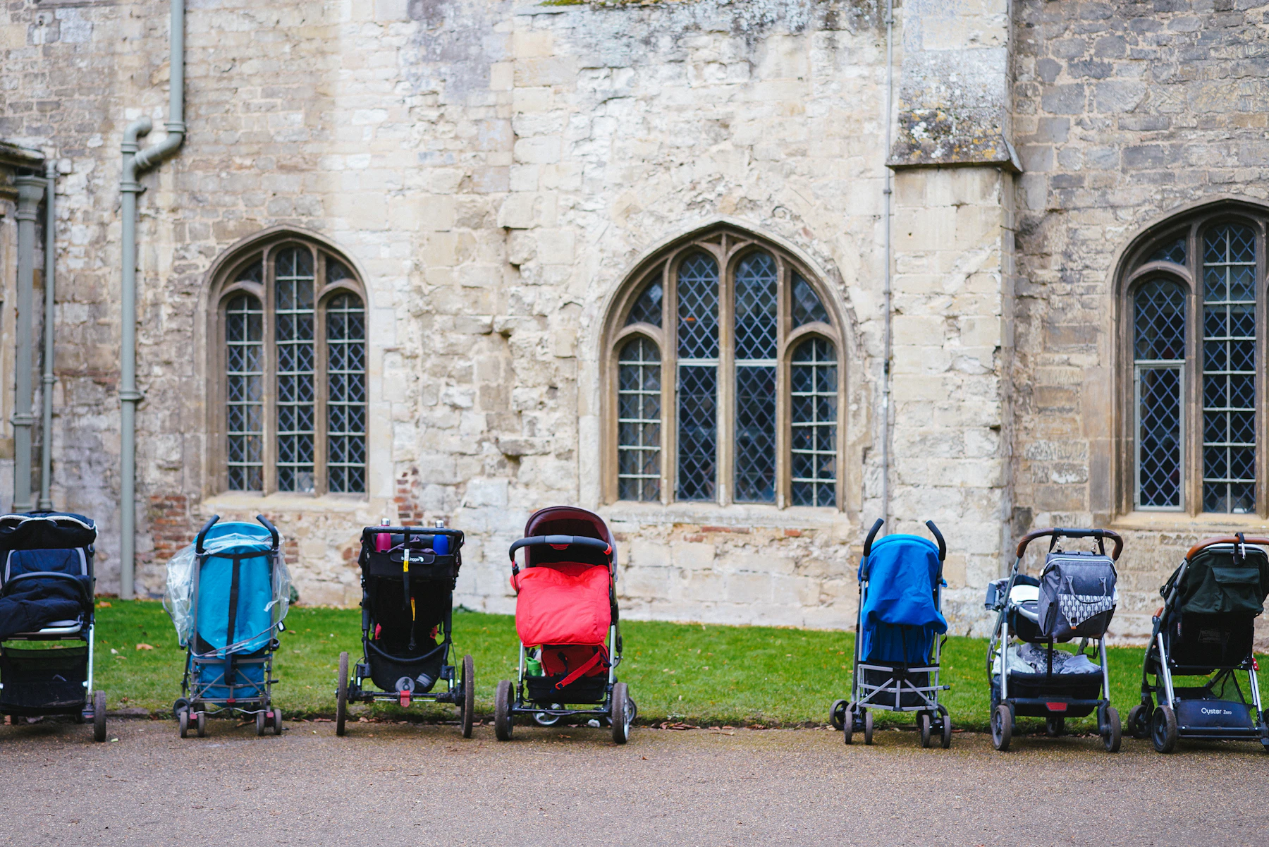 Row of colorful strollers parked outside